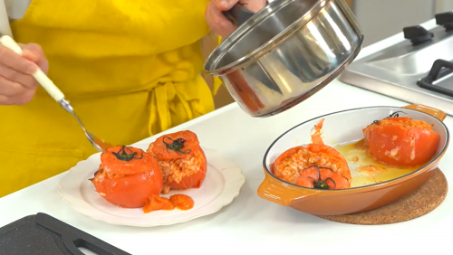 オーブンから取り出したトマトをお皿に移し、煮詰めたトマトの中身とハーブを添える。