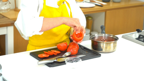 トマトの上部を切り、スプーンで中をくり抜く。ヘタがついた部分は捨てずに取っておく。トマトに塩を振り逆さまに置き、トマトの中身を鍋に入れて弱火で火にかける。
